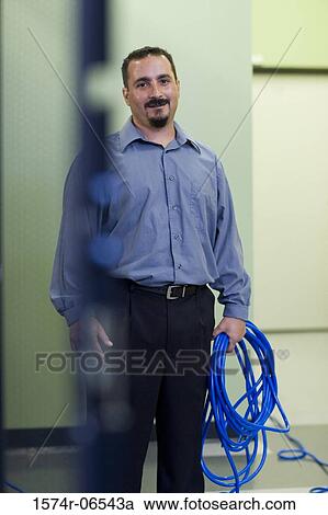 Stock Image - Portrait of a technician holding computer cables. Fotosearch