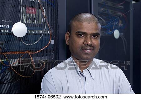 Stock Image - Portrait of a technician in a server room. Fotosearch