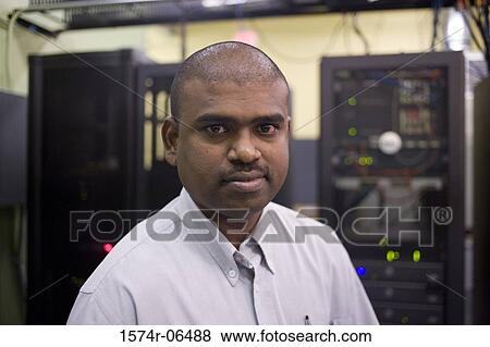 Stock Photo - Portrait of a technician standing in a server room. Fotosearch