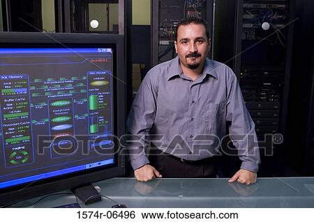 Stock Photograph - Portrait of a technician standing in a server room. Fotosearch