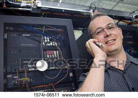 Stock Image - Portrait of a technician talking on a mobile phone. Fotosearch