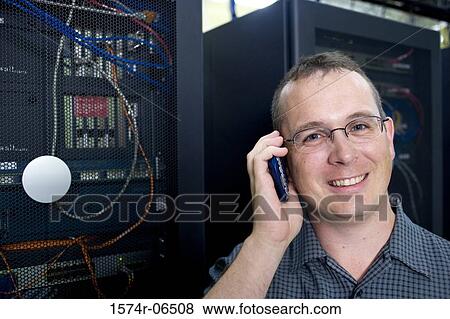 Stock Photo - Portrait of a technician talking on a mobile phone. Fotosearch