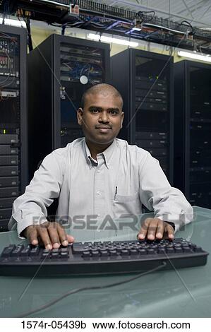 Stock Image - Portrait of a technician using a computer in a server room. Fotosearch