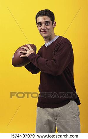 Stock Photo - Portrait of a teenage boy holding a football. Fotosearch