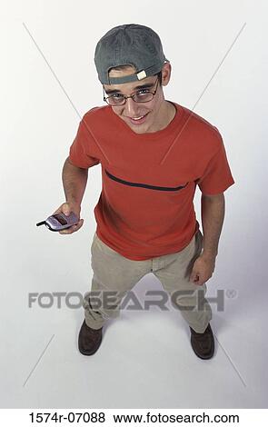 Portrait of a teenage boy holding a mobile phone View Large Photo Image Stock Photo - Portrait of a teenage boy holding a mobile phone. Fotosearch