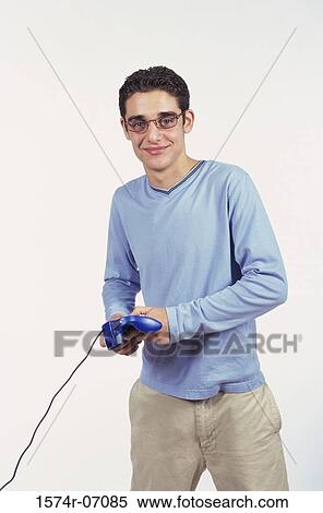 Portrait of a teenage boy holding a game joystick View Large Photo Image Stock Photography - Portrait of a teenage boy holding a game joystick. Fotosearch