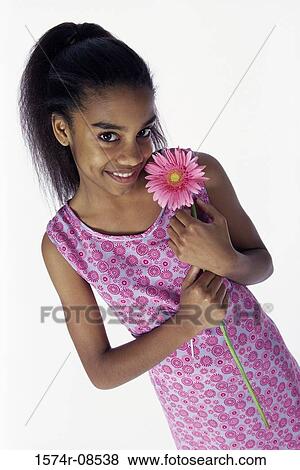Portrait of a teenage girl holding a flower View Large Photo Image Stock Photo - Portrait of a teenage girl holding a flower. Fotosearch