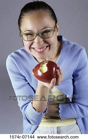 Picture - Portrait of a teenage girl holding an apple smiling. Fotosearch