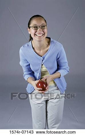 Portrait of a teenage girl holding an apple smiling View Large Photo Image Stock Image - Portrait of a teenage girl holding an apple smiling. Fotosearch