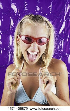 Portrait of a teenage girl holding her pigtails View Large Photo Image Stock Photo - Portrait of a teenage girl holding her pigtails. Fotosearch