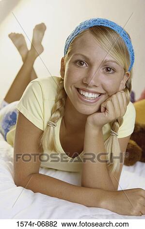 Portrait of a teenage girl lying on a bed View Large Photo Image Stock Image - Portrait of a teenage girl lying on a bed. Fotosearch