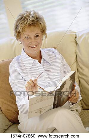 Portrait of a woman sitting on a couch View Large Photo Image Stock Image - Portrait of a woman sitting on a couch. Fotosearch