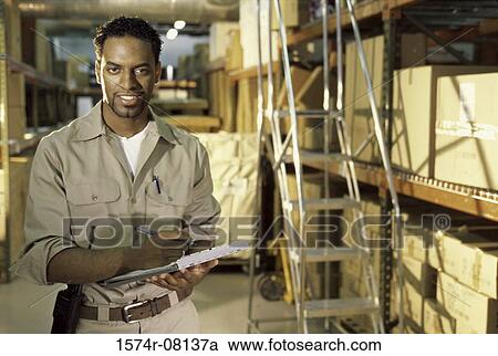 Portrait of a worker holding a clipboard smiling View Large Photo Image Stock Image - Portrait of a worker holding a clipboard smiling. Fotosearch
