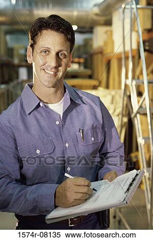 Portrait of a worker holding a clipboard smiling View Large Photo Image Stock Photography - Portrait of a worker holding a clipboard smiling. Fotosearch