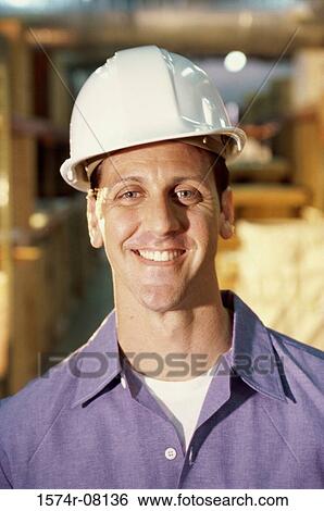 Stock Photograph - Portrait of a worker wearing a hardhat smiling. Fotosearch