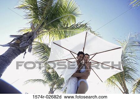 Portrait of a young couple embracing on the beach View Large Photo Image Stock Image - Portrait of a young couple embracing on the beach. Fotosearch