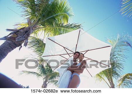 Portrait of a young couple embracing on the beach View Large Photo Image Stock Image - Portrait of a young couple embracing on the beach. Fotosearch