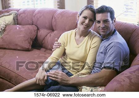Portrait of a young couple sitting on a couch View Large Photo Image Stock Image - Portrait of a young couple sitting on a couch. Fotosearch