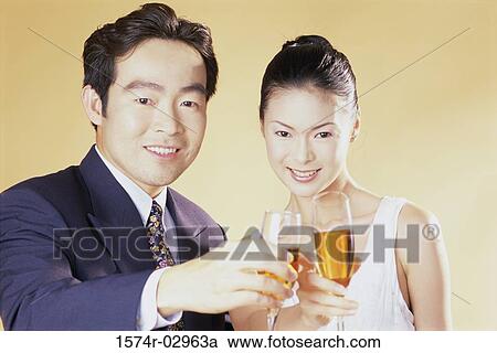 Stock Image - Portrait of a young couple toasting. Fotosearch