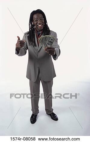 Stock Photo - Portrait of a young man holding paper money. Fotosearch