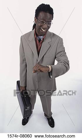 Stock Image - Portrait of a young man standing holding a briefcase. Fotosearch