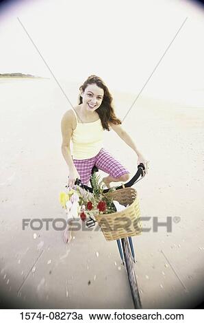 Portrait of a young woman cycling on the beach View Large Photo Image Stock Image - Portrait of a young woman cycling on the beach. Fotosearch
