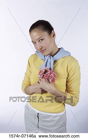 Portrait of a young woman holding a bunch of flowers View Large Photo Image Stock Image - Portrait of a young woman holding a bunch of flowers. Fotosearch