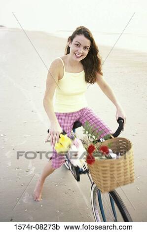 Portrait of a young woman sitting on a bicycle View Large Photo Image Stock Image - Portrait of a young woman sitting on a bicycle. Fotosearch