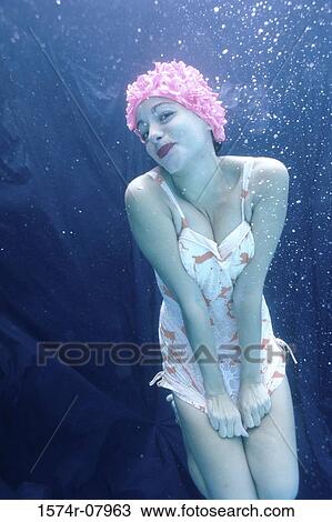 Stock Image - Portrait of a young woman smiling underwater. Fotosearch