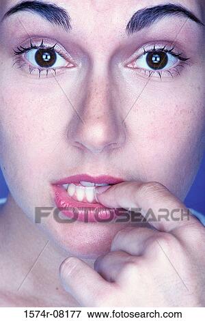 Portrait of a young woman with her finger in her mouth View Large Photo Image Stock Photo - Portrait of a young woman with her finger in her mouth. Fotosearch