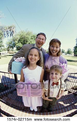 Picture - Portrait of parents standing with their son and daughter. Fotosearch