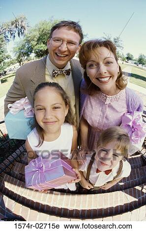 Stock Image - Portrait of parents standing with their son and daughter. Fotosearch