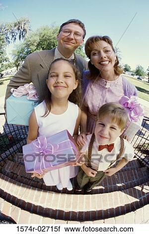 Stock Image - Portrait of parents standing with their son and daughter. Fotosearch