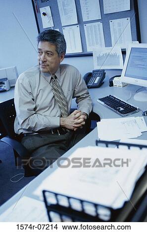 Picture - Portrait of senior businessman seated at an office desk. Fotosearch