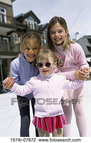 Stock Image - Portrait of three girls ice skating. Fotosearch