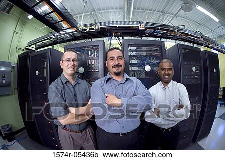 Stock Image - Portrait of three technicians standing in a server room. Fotosearch