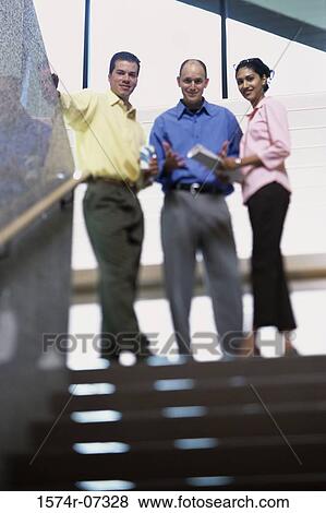 Portrait of two businessmen and a businesswoman standing at the top of a staircase View Large Photo Image Stock Photo - Portrait of two businessmen and a businesswoman standing at the top of a staircase. Fotosearch