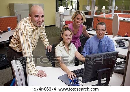 Picture - Portrait of two businessmen and two businesswomen working on a computer. Fotosearch
