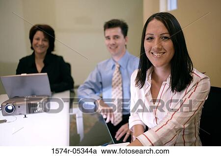 Portrait of two businesswomen and a businessman sitting in a conference room View Large Photo Image Stock Image - Portrait of two businesswomen and a businessman sitting in a conference room. Fotosearch