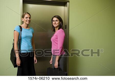 Portrait of two businesswomen standing near an elevator View Large Photo Image Stock Image - Portrait of two businesswomen standing near an elevator. Fotosearch