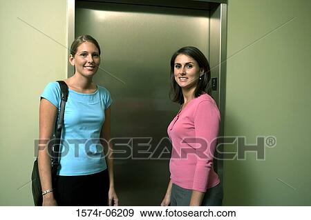 Portrait of two businesswomen standing near an elevator View Large Photo Image Stock Photo - Portrait of two businesswomen standing near an elevator. Fotosearch