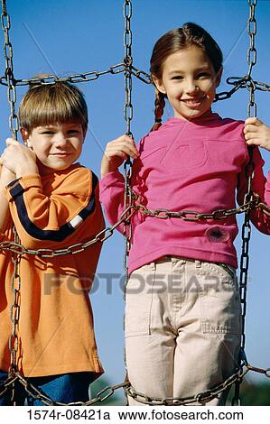 Portrait of two children playing on a jungle gym View Large Photo Image Stock Image - Portrait of two children playing on a jungle gym. Fotosearch