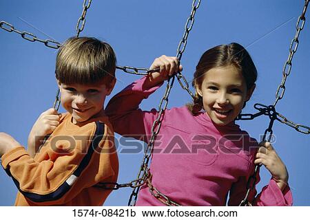 Portrait of two children playing on a jungle gym View Large Photo Image Stock Image - Portrait of two children playing on a jungle gym. Fotosearch