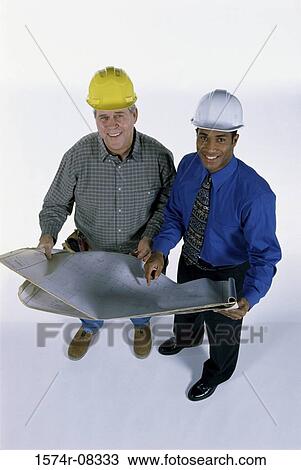 Stock Image - Portrait of two foremen holding blueprints. Fotosearch