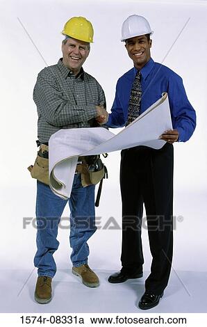 Stock Image - Portrait of two foremen shaking hands over a blueprint. Fotosearch