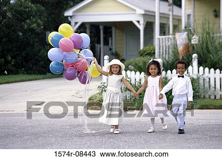 Portrait of two girls and a boy walking together holding hands View Large Photo Image Stock Image - Portrait of two girls and a boy walking together holding hands. Fotosearch