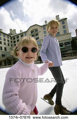 Stock Photograph - Portrait of two girls ice skating together. Fotosearch