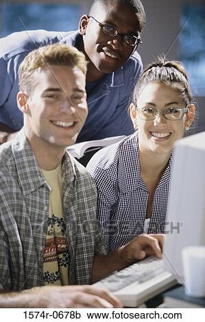 Stock Image - Portrait of two young men and a young woman smiling. Fotosearch