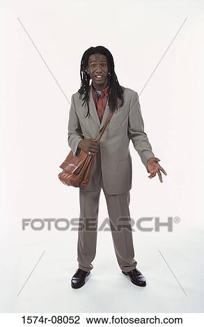Stock Image - Portrait of young man standing holding a briefcase. Fotosearch