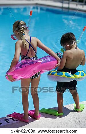 Rear view of a boy and a girl standing at the poolside wearing snorkels and flippers View Large Photo Image Picture - Rear view of a boy and a girl standing at the poolside wearing snorkels and flippers. Fotosearch